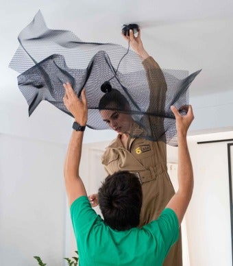 Joana Laranjeira e marido a colocar o candeeiro de chapa metálica no teto
